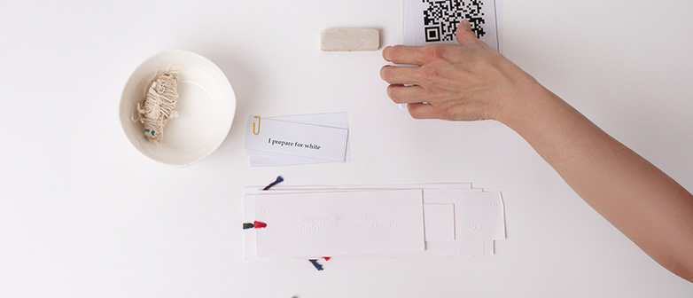Eine Sammlung weiser Gegenstände und eine Hand, die nach einem QR-Code greift
