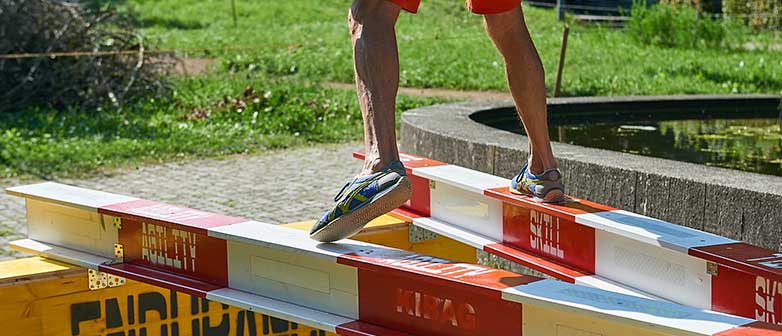 Mann balanciert über zwei Stangen