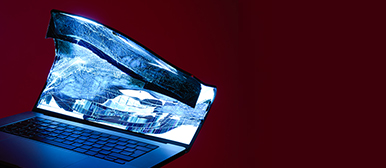 Ein zerbrochener Computer, der neonblau leuchtet. Der Hintergrund ist Weinrot. Das ist der Newsfeed der HSLU Design Film Kunst.