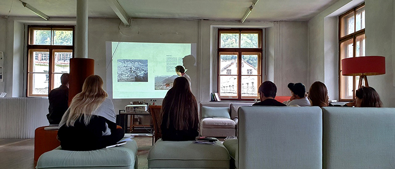 Das Bild zeigt Personen in einem Raum die einer Veranstaltung folgen.