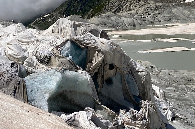     Gletscherlandschaft mit teilweise abgedecktem Eis, sichtbar schmelzende Umgebung als Hinweis auf Klimawandel und ökologische Veränderungen.
