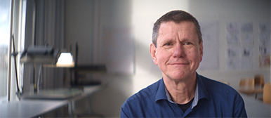 Gerd Gockel, Dozent für Animation an der HSLU Design Film Kunst, vor Regalen mit bunten Garnrollen im Fachbereich Textiles.