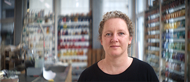 Maja Gehrig, Dozentin im Bereich Animation an der HSLU Design Film Kunst, in der Werkstatt mit Regalen voller Farbpigmente.