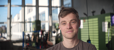 Tim Markgraf, Dozent für Animation an der HSLU Luzern, im Werkraum mit Ausblick auf den Campus der Hochschule.