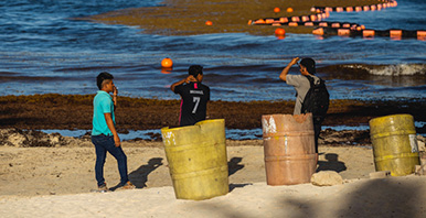 Junge Menschen an einem verschmutzten Strand