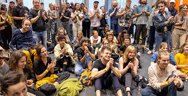 Viele Leute sitzen am Boden und klatschen