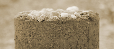 Ein Sandturm mit weissen Steinen auf der Oberfläche. 