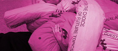 Ein pinkes Bild von einer Person, die ein Kissen umarmt. 