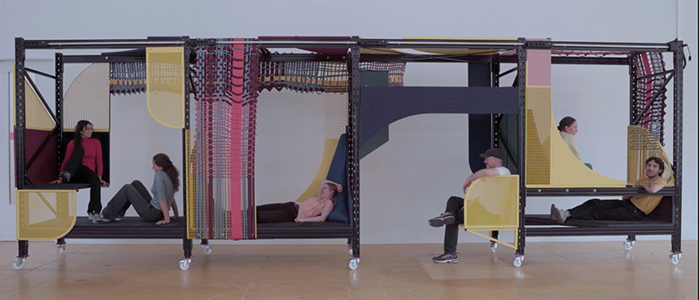 Eine Holz - und Stoffstruktur, auf der man sitzen und verweilen kann. Die Studierenden von Objektdesign, die das 