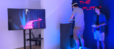 Eine Virtual Reality-Installation, die von zwei Studenten in einem in Blau belichteten Raum gesteuert wird