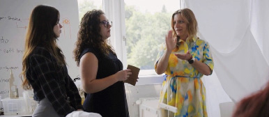 Drei Dozentinnen im Gespräch miteinander vor einem Fenster, das die grüne Natur zeigt
