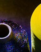 Zwei Fadenspulen von nah, eine dunkelblau, die andere gelb