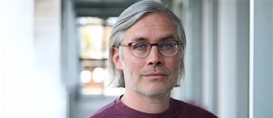 Ein Bild von Volko Kamensky vor eine langen Gang.