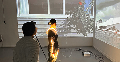 Beamer Projektion übers Eck, vor der zwei Personen stehen