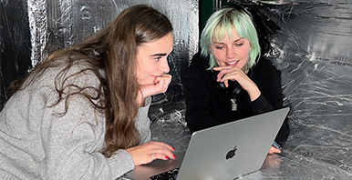 Zwei Studierende arbeiten am Laptop