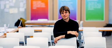 Portrait von Noah Büchel, auf weissen Stühlen sitzend und ganz in schwarz gekleidet