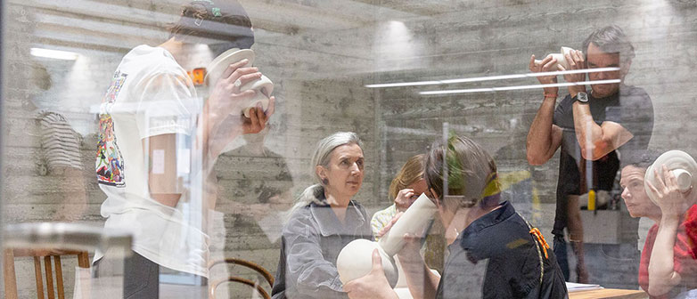 Besucher:innen erleben eine Ausstellung, indem sie sich Tongefässe an die Ohren halten udn auf die verschiedenen Geräusche lauschen. StudioLab Days 2024, Foto Misch Christen