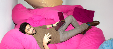 Unkonventionelle Lernorte – Studierender der HSLU Design Film Kunst entspannt mit Laptop auf kreativem Sitzmöbel.