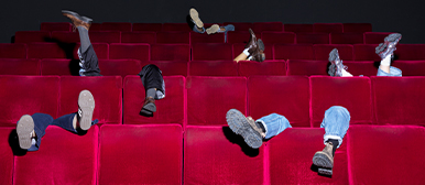 Verspielte Perspektive im Hörsaal – Studierende der HSLU Design Film Kunst in den roten Kinosesseln des Campus.