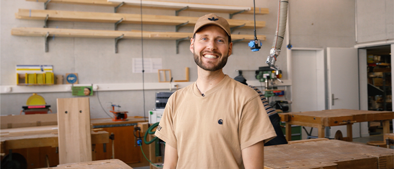 Lachender Mann in einer Holzwerkstatt, Teaser für ein Video über die Werkstätte der HSLU – Design Film Kunst. 