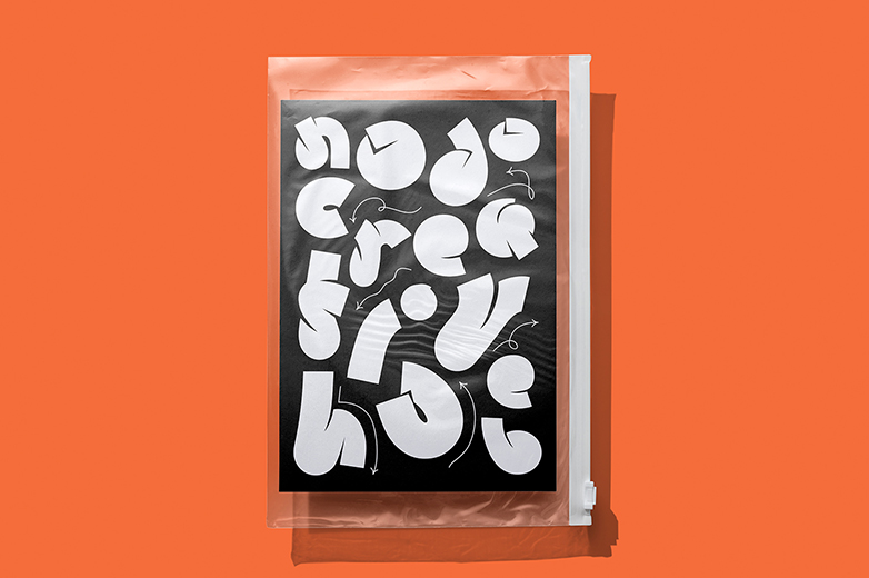 Ein Plastikbeutel mit dem schwarz-weiss Nodologo darin, der Hintergrund ist eine orange Fläche. 