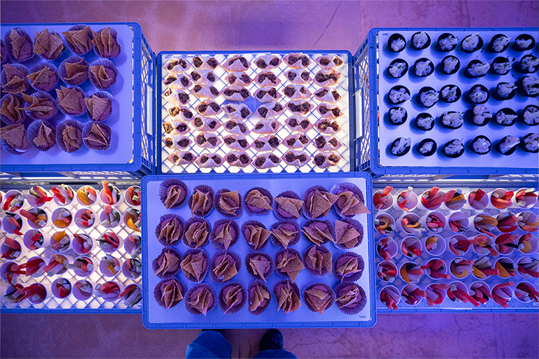 Apéro und Veranstaltung der Food installation Helga Luzern 2024: modulare Snack-Installation aus gestapelten Kisten, Publikum im Austausch sowie Einblicke in Präsentation und Eventsetting.