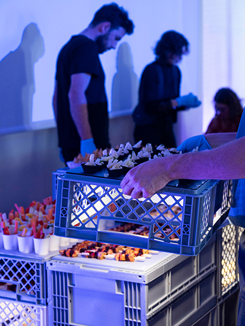 Apéro und Veranstaltung der Food installation Helga Luzern 2024: modulare Snack-Installation aus gestapelten Kisten, Publikum im Austausch sowie Einblicke in Präsentation und Eventsetting.