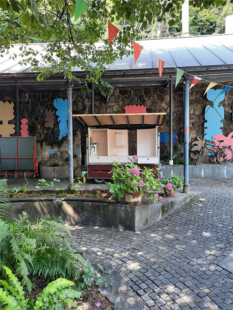 Bunt gestaltete Plakate und Drucksachen im öffentlichen Raum sowie Szenen eines lebendigen Quartiertreffs mit Menschen, Pflanzen und gemeinschaftlichen Aktivitäten im Aussenbereich.