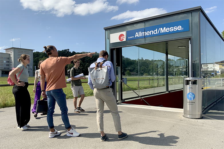 Gestalterische Interventionen im öffentlichen Raum rund um die Allmend/Messe Luzern, mit Beschriftungen, historischen Bezügen und Menschen in Bewegung an Haltestellen, Treppen und Zugängen.