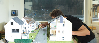 Architekturmodell in der Lehre – Studierender an der HSLU Design Film Kunst arbeitet an einem Stadtteil-Modell im Atelier.