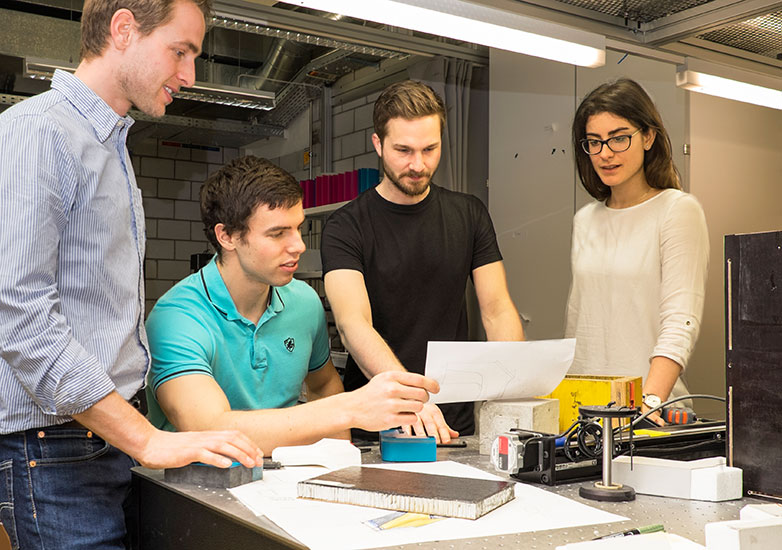 Hochkonzentriert gemeinsam bei der Arbeit: Jonathan Folberth, Tom Reuter und Clara Beck von TapTools (von links) und Moritz Reich vom Design-Team der Hochschule Luzern (stehend in Schwarz).