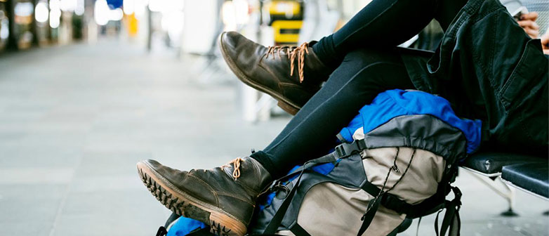 Person sitting at the train station with a backpack