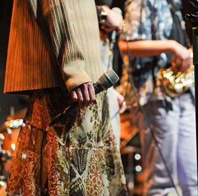 Zwei Musiker:innen mit Mikrofon und Gitarre