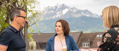 Drei Menschen stehen auf der Terrasse des Departements Wirtschaft