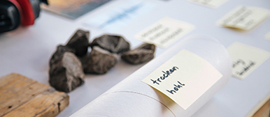 Material, Steine, Zettel auf einem Tisch