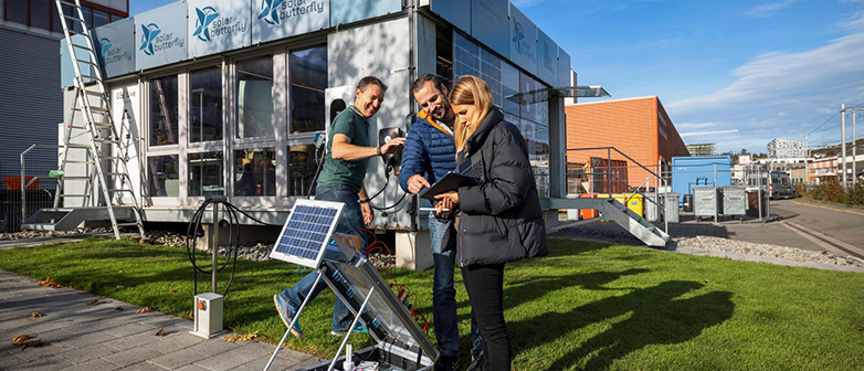 Menschen stehen hinter einem Solarpanel