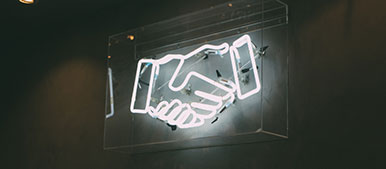 Bild zeigt eine Leuchtröhre, auf der sich zwei Hände berühren