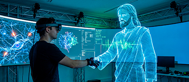 Ein Mann mit VR-Brille schüttelt einer Projektion von Jesus die Hand