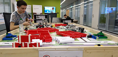 Ein Junge sitzt vor einem Tisch mit verschiedenen Bauteilen