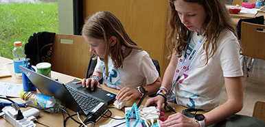 Zwei Mädchen arbeiten an einem Roboter