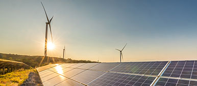 Windräder und Solarpanels in Landschaft