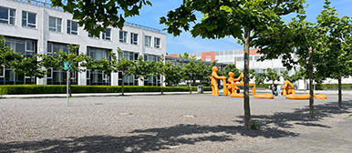 The building from outside with orange statues in the front