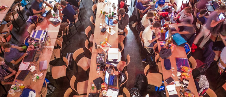 Tische in Reihen und vereinzelte Menschen die arbeiten