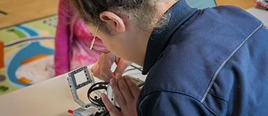 Ein Mädchen arbeitet an einem Lego-Roboter