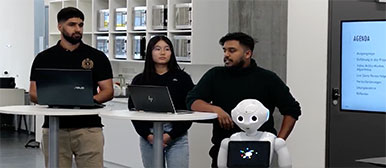 Drei Studierende halten einen Vortrag und der Roboter Pepper steht im Vordergrund