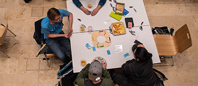 Mehrere Personen sitzen an einem Tisch und spielen Spiele.