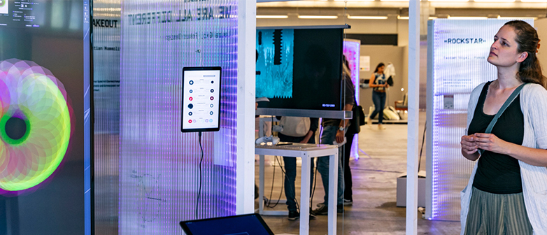 Eine Frau betrachtet eine digitale Instillation. 