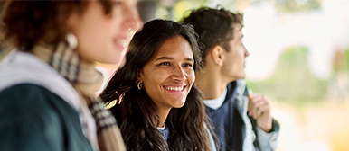 Drei Studierende, seitlich fotografiert und lächelnd