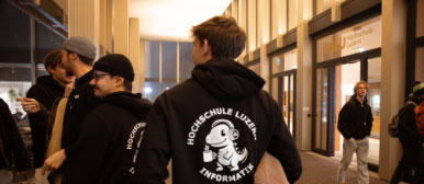 Ein Student mit schwarzem Hoodie von hinten
