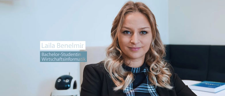 Prortrait einer Wirtschaftsinformatik-Studentin vor ihrem Arbeitsplatz 